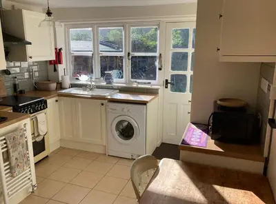 a kitchen with a washing machine and a window at Lovely peaceful 2 bed cottage in Llandderfel