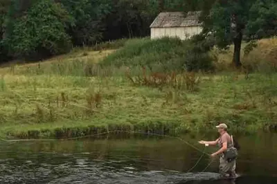 a man in the water fishing in a river at Lovely peaceful 2 bed cottage in Llandderfel