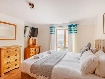 a bedroom with a white bed and a window at 3 Bed in Corwen oc-90459 in Corwen