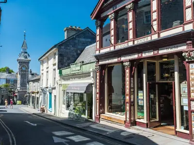 a row of shops on a city street with a clock tower at 4 Bed in Painscastle 90375 in Builth Wells