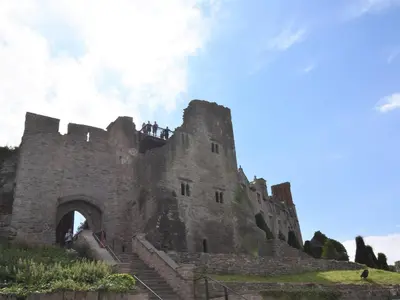 a castle on a hill with people standing on it at 4 Bed in Painscastle 90375 in Builth Wells