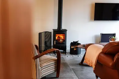 a living room with a wood stove in a room at Pigeon House - Unique Barn with private garden, hot tub and wood burner in Shrewsbury
