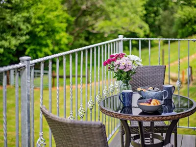 a table with a vase of flowers and a bowl of fruit at 1 Bed in Church Stretton oc-90929 in All Stretton
