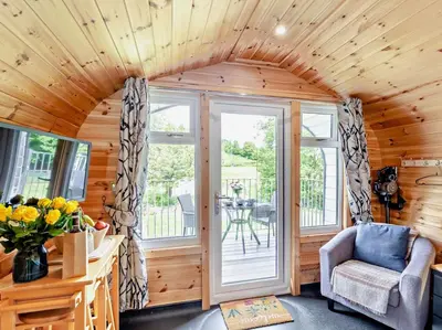 a living room with a wooden ceiling and a room with a chair at 1 Bed in Church Stretton oc-90929 in All Stretton