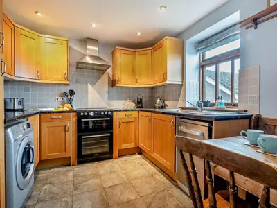 a kitchen with wooden cabinets and a dishwasher at 2 Bed in Brecon oc-91085 in Llangorse