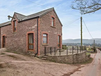 an old brick house with a fence on a dirt road at 2 Bed in Brecon oc-91085 in Llangorse
