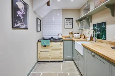 a kitchen with a sink and a stove top oven at Romantic Country Cottage with log burner, garden patio, outdoor tub and country views- Brecon Beacons National Park in Llangadog