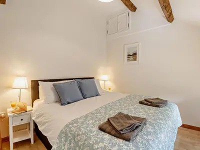 a bedroom with a large bed with blue pillows at 6 Bed in Harlech oc-91546 in Harlech