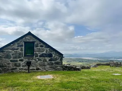 an old stone building with a window in a field at 6 Bed in Harlech oc-91546 in Harlech