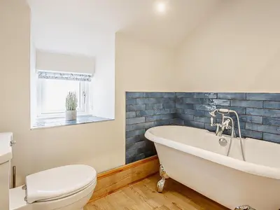 a bathroom with a white tub and a toilet at 6 Bed in Harlech oc-91546 in Harlech