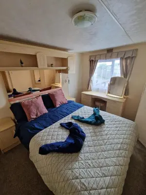 a bedroom with a large bed with blue towels on it at Haven on the Hill 2 Bed Caravan with Town Views of Aberystwyth F7 in Aberystwyth