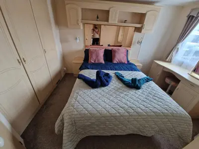 a small room with a bed with two blue shoes on it at Haven on the Hill 2 Bed Caravan with Town Views of Aberystwyth F7 in Aberystwyth
