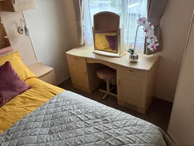 a bedroom with a bed and a desk with a mirror at Haven on the Hill 2 Bed Caravan with Town Views of Aberystwyth F7 in Aberystwyth