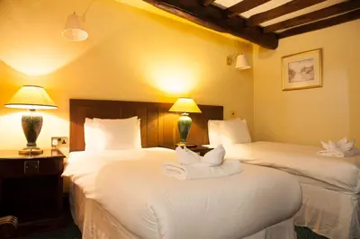 a hotel room with two beds with towels on them at The Kings Head Inn in Llandovery