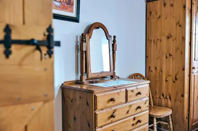 a wooden dresser with a mirror on top of it at Finest Retreats - The Walton in Onibury