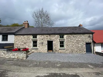 a stone house with a red roof at No 2 Dolheulog Aberaeron in Aberaeron