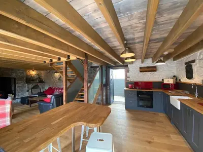 a kitchen and living room with a long wooden table at No 2 Dolheulog Aberaeron in Aberaeron