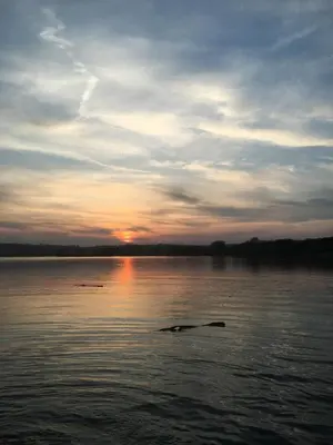 a body of water with a sunset in the background at Brecon serviced apartments- Kian Perrott Properties in Brecon