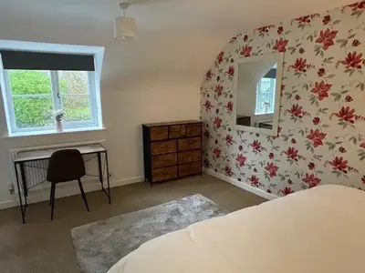 a bedroom with a bed and a desk and a mirror at Beech Cottage with Clun Castle View in Clun