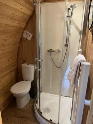 a bathroom with a shower and a toilet in a cabin at Mountain Edge Resort Mega pod 5 with Hot Tub in Church Stretton