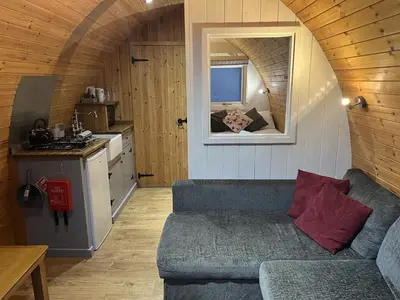 a living room with a couch in a tiny house at Mountain Edge Resort Mega pod 5 with Hot Tub in Church Stretton