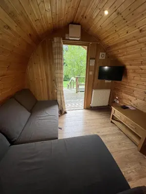 a bedroom with a bed and a tv in a room at Mountain Edge Resort Mega pod 5 with Hot Tub in Church Stretton