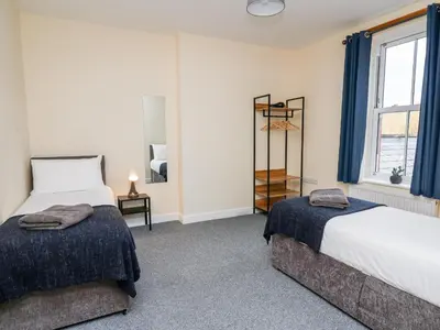 a bedroom with two beds and a window at Afonwy House in Rhayader
