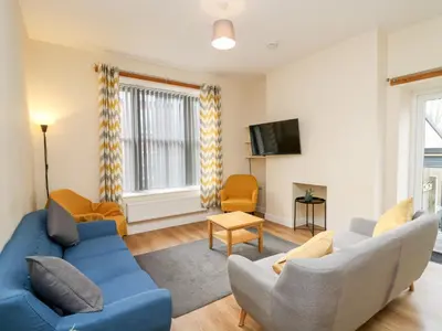 a living room with a blue couch and chairs at Afonwy House in Rhayader