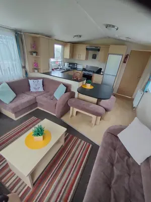a living room with a couch and a table at M&C Caravan Hire Sunnysands in Barmouth