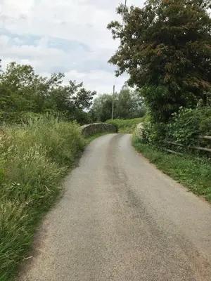 a dirt road with a bridge in the distance at Leverets - Squirrel Lane Lodges Ludlow in Ludlow