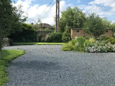 a gravel driveway in a garden with flowers at The Nut House - Squirrel Lane Lodges Ludlow in Ludlow