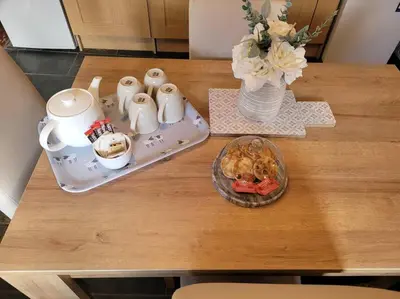 a table with a plate of food and a vase of flowers at Cosy modern cottage by the sea, heart of snowdonia in Llwyngwril