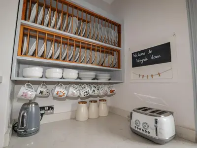 a kitchen with cups and saucers on a counter at Wayside House in Craven Arms