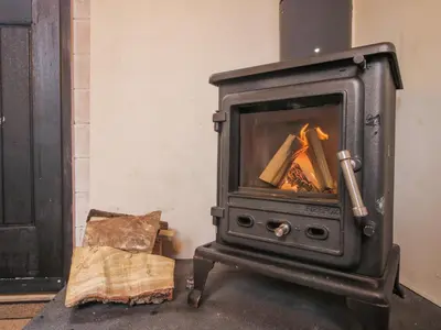 a wood stove in a living room with at Aston - Shepherd Hut in Craven Arms
