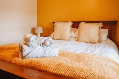 a bedroom with a bed with towels on it at Luxury 5-Bed Farmhouse - Sleeps 8 & Hot Tub in Brecon