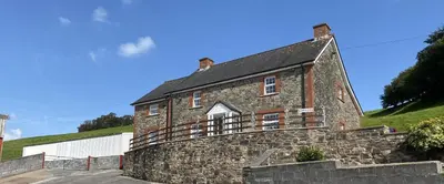 an old stone house with a stone wall at Luxury 5-Bed Farmhouse - Sleeps 8 & Hot Tub in Brecon