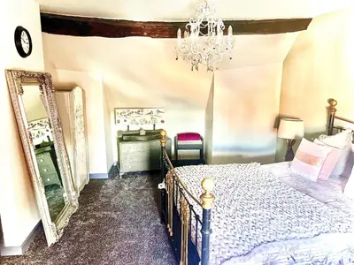 a bedroom with a bed and a mirror and a chandelier at Little Libertys in Shrewsbury