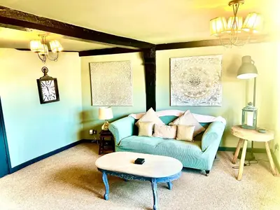 a living room with a blue couch and a table at Little Libertys in Shrewsbury