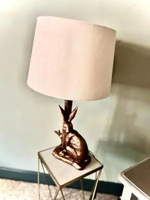 a bronze lamp sitting on a table with a lamp shade at Little Libertys in Shrewsbury