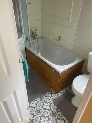 a bathroom with a bath tub and a toilet at Spacious Luxury Escape with Sea Views and Pet Friendly at Clarach Bay in Aberystwyth