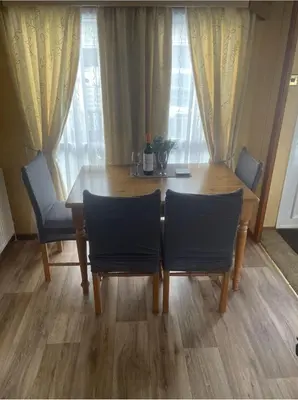 a dining room table with two chairs and a wooden table at Spacious Luxury Escape with Sea Views and Pet Friendly at Clarach Bay in Aberystwyth