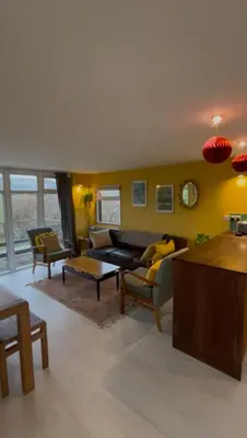 a living room with a couch and a table at The Deckhouse, cabin with big deck nr Hay-on-Wye in Rhos-gôch