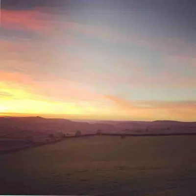 an open field with a sunset in the sky at The Deckhouse, cabin with big deck nr Hay-on-Wye in Rhos-gôch