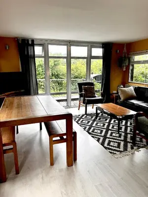 a living room with a table and a couch at The Deckhouse, cabin with big deck nr Hay-on-Wye in Rhos-gôch