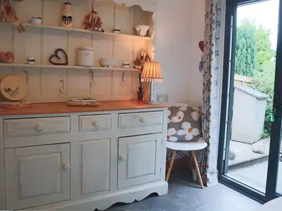 a room with a dresser with a lamp and a chair at Aragon Cottage in Ludlow