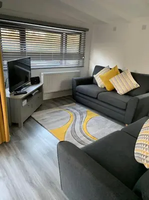 a living room with a couch and a television at Lakeside retreat - Lodge 2F caer beris holiday park - no commercial vehicles allowed on site in Builth Wells