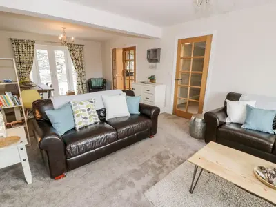 a living room with two leather couches and a table at Ty Ni in Dyffryn