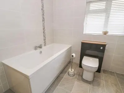 a white bath tub in a bathroom with a toilet at Ty Ni in Dyffryn