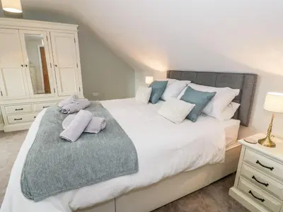 a bedroom with a large bed with towels on it at Ty Ni in Dyffryn