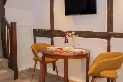 a table with two chairs and a bottle of wine at Hideaway Cottage in Ludlow